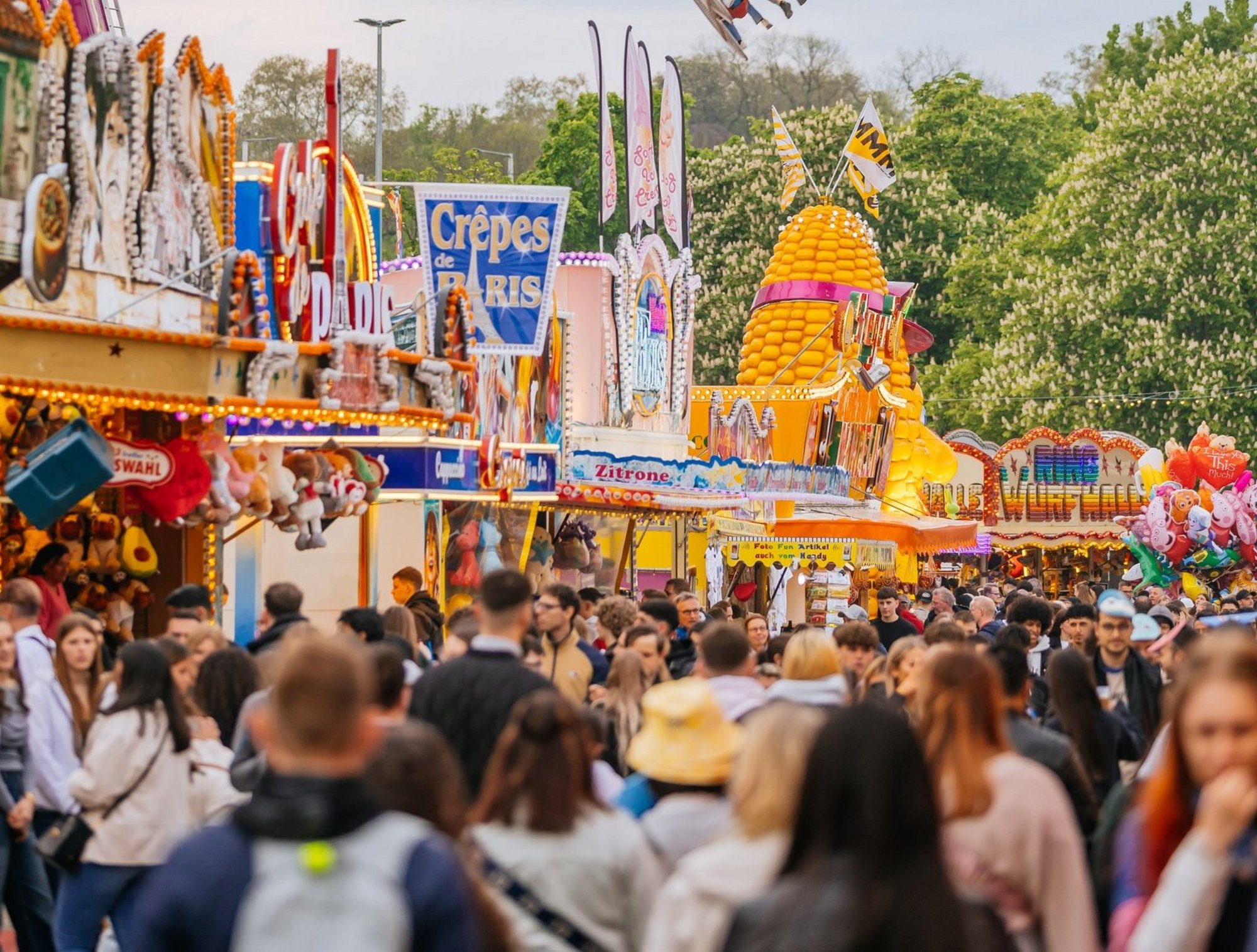 Eine Feststraße mit zahlreichen Ständen und Menschen