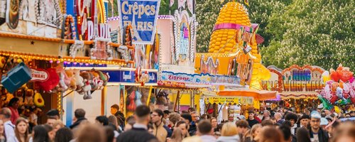 Eine Feststraße mit zahlreichen Ständen und Menschen