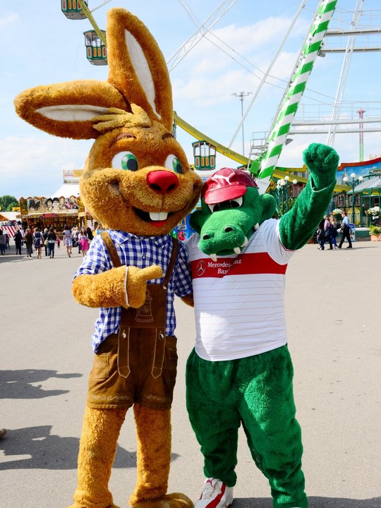 Wasenmaskottchen "Wasi" auf dem Volksfest mit dem VfB-Maskottchen Fritzle im Arm.