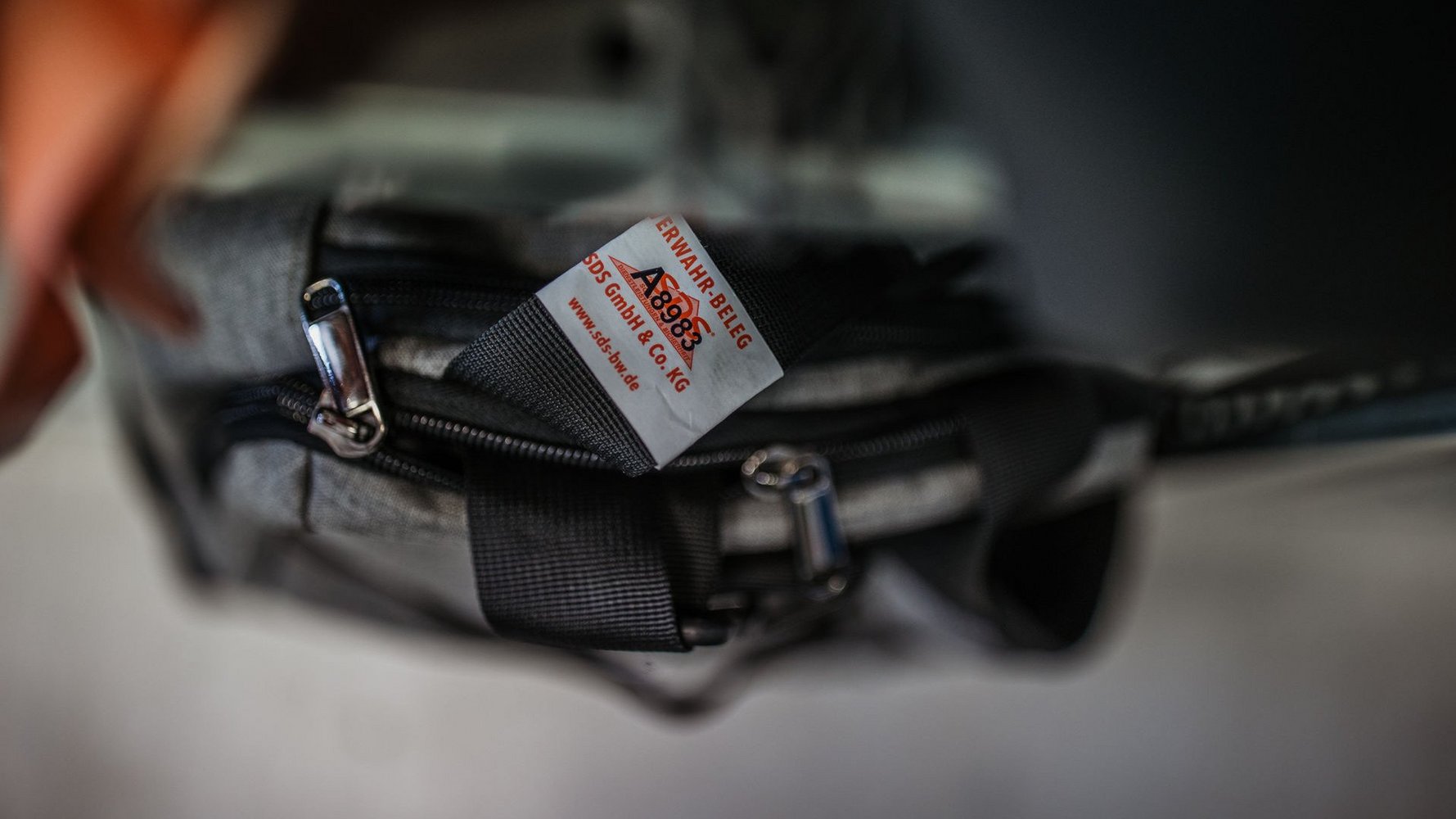 Eine Tasche mit einem Verwahr-Beleg an einem der Griffe.