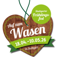 Das Holzherz des Frühlingsfestes. Darauf steht in weißer Schrift "Auf zum Wasen". Darunter auf einer grünen Banderole "18.04. bis 10.05.26". Oben rechts ist ein grüner Kreis, darin steht "Stuttgarter Frühlingsfest".
