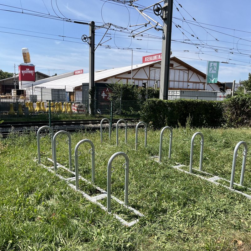 [Translate to English:] Fahrradstellplätze an der Stadtbahnhaltestelle "Cannstatter Wasen" auf einer Wiese.