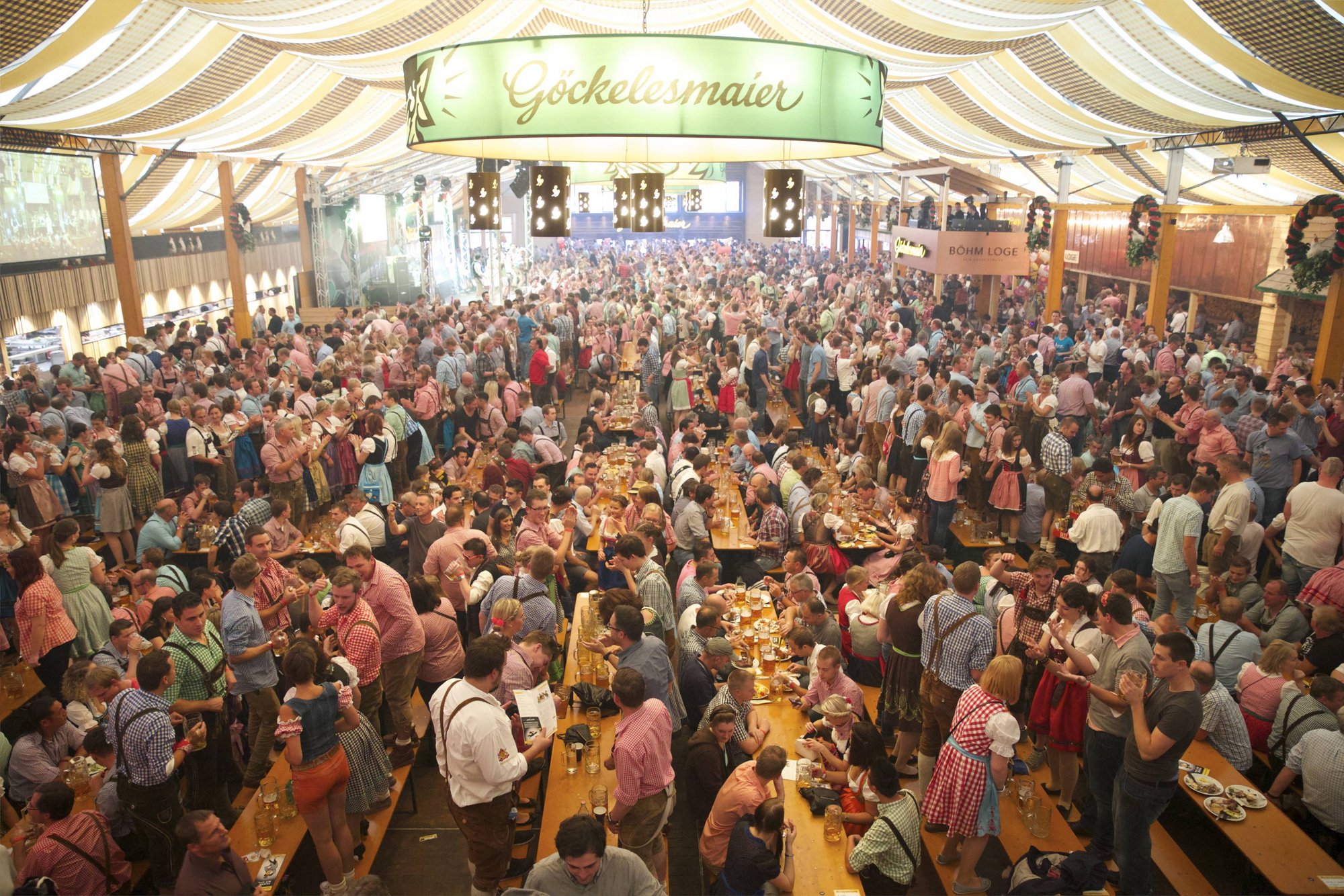 Innenansicht des Göckelesmaier-Festzeltes von einer Empore herab auf die feiernden Menschen