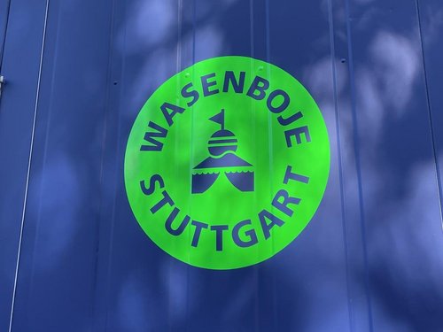 Das grüne Logo der Wasenboje Stuttgart auf blauem Hintergrund.